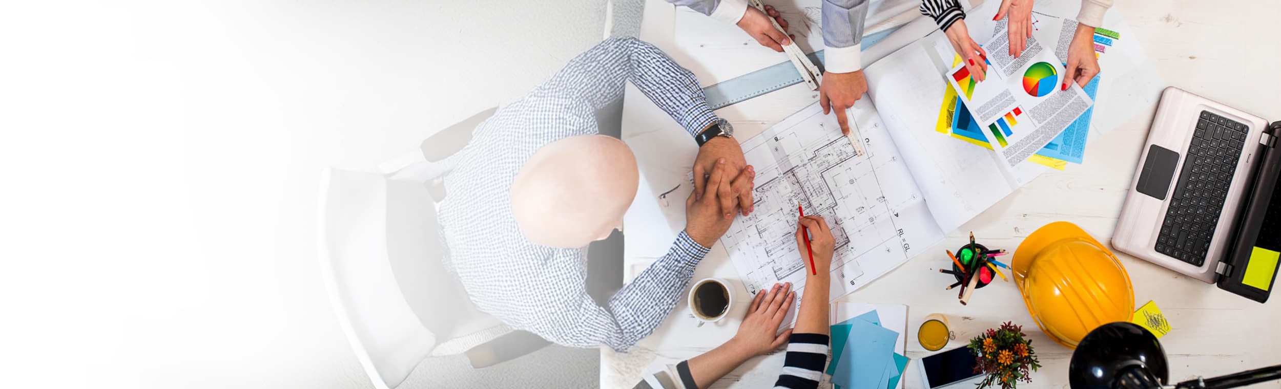 Over head shot of executives looking at drawings and graphs