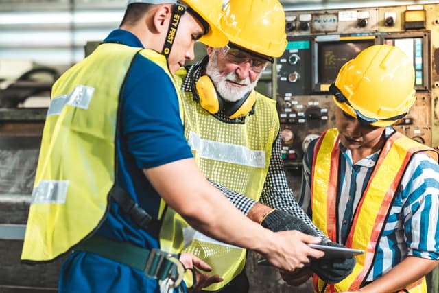 Three construction workers looking at an iPad 1200x800