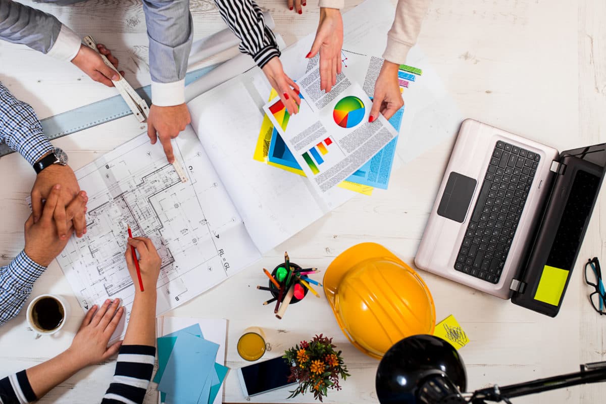 Construction executives looking at drawings and graphs 1200x800